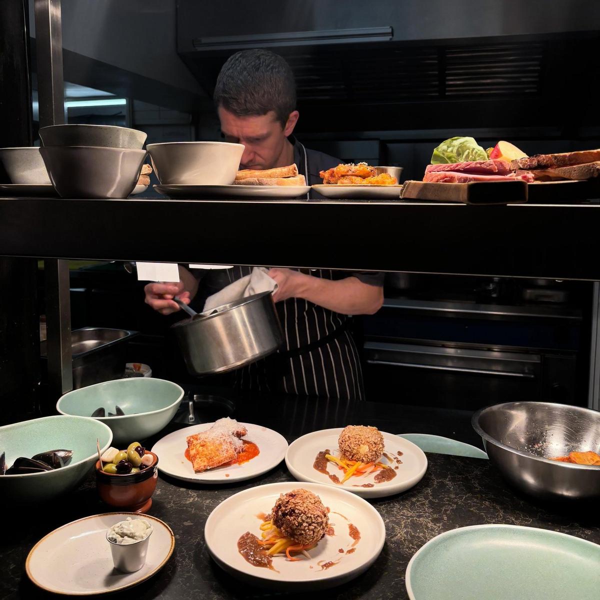 A chef plating a dish in The Yew Tree kitchen